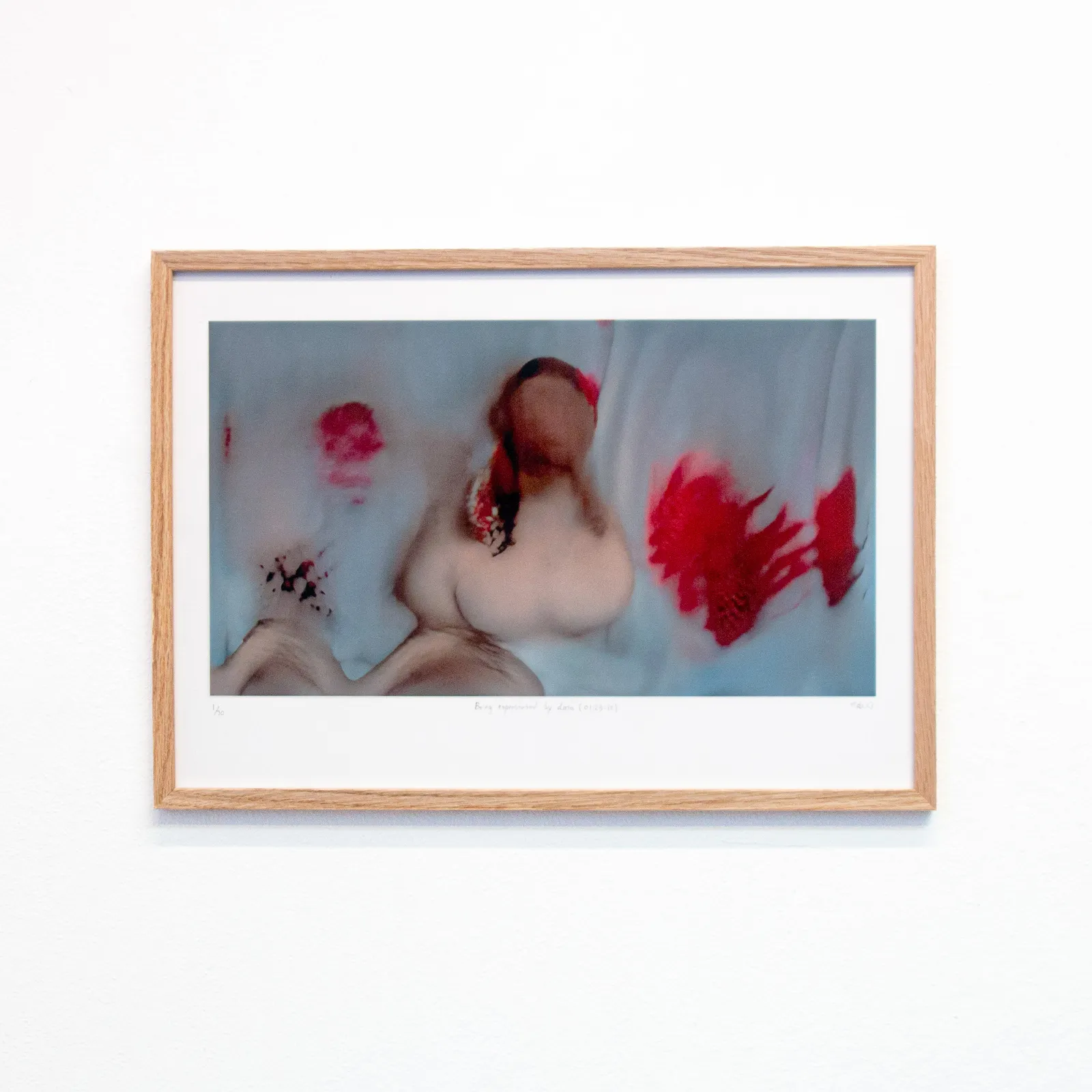 A framed version of a red, glitchy still of "Being represented by data is like losing a part of yourself"