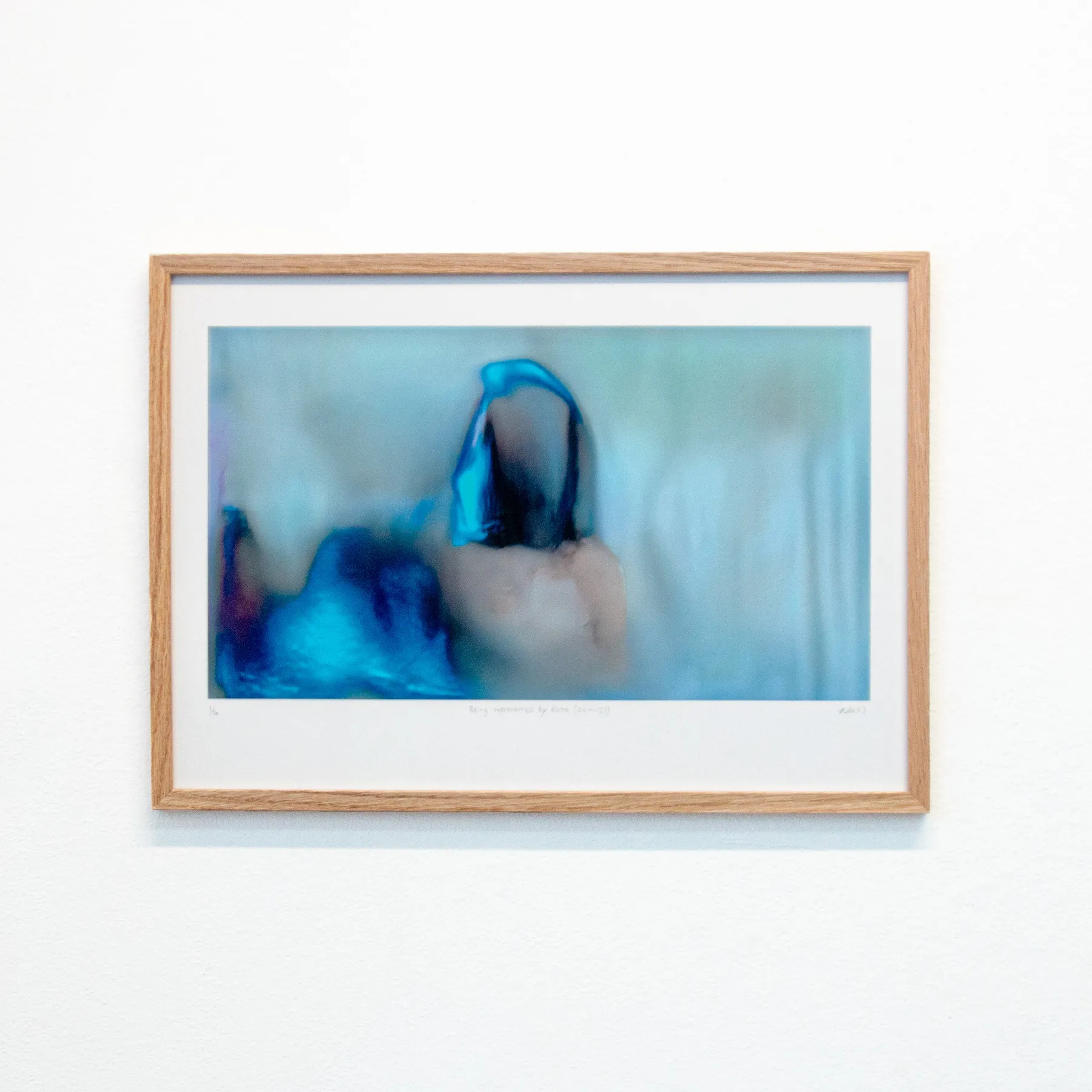 A framed version of a blue, glitchy still of "Being represented by data is like losing a part of yourself"