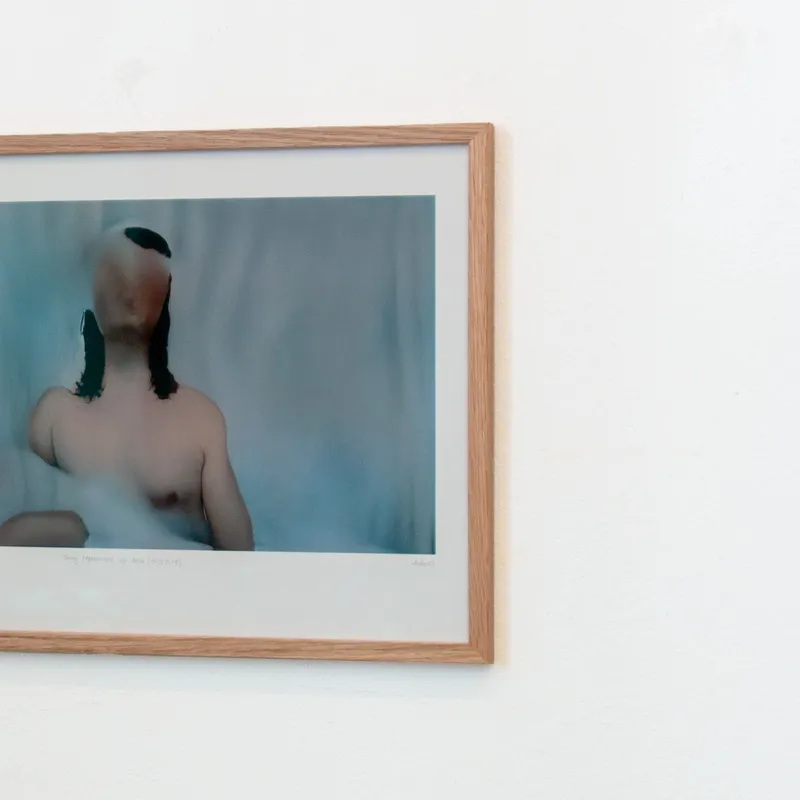 A sideways look at a framed version of a fleshy, glitchy still of "Being represented by data is like losing a part of yourself"